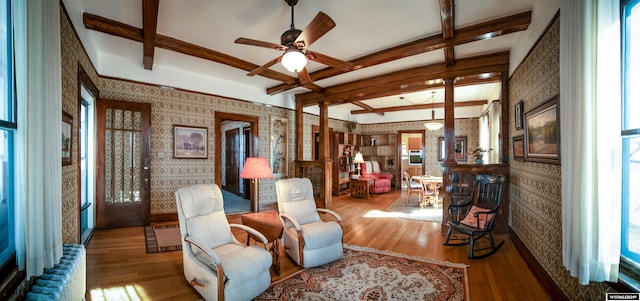 living area featuring hardwood / wood-style flooring, ceiling fan, and beam ceiling