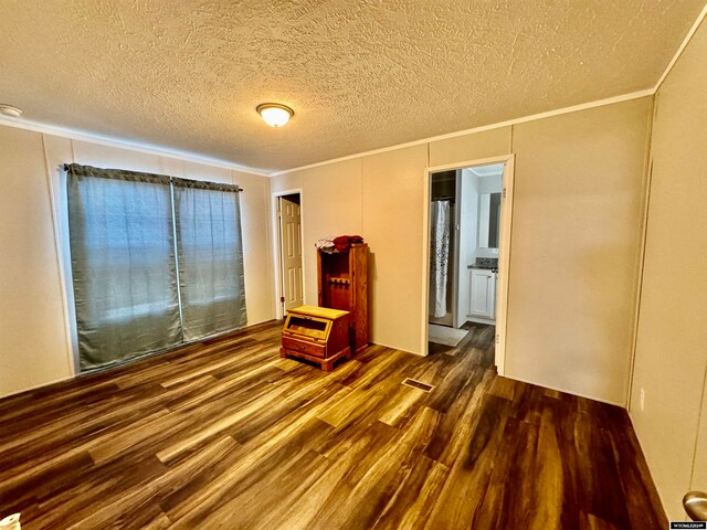 interior space with dark hardwood / wood-style floors, a textured ceiling, and ornamental molding