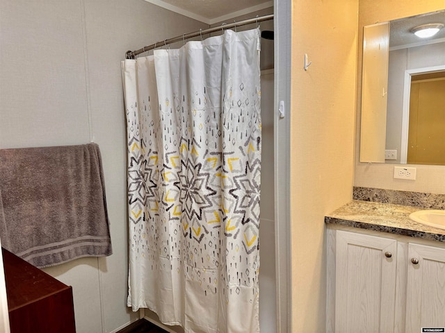 bathroom featuring a shower with shower curtain, vanity, and ornamental molding