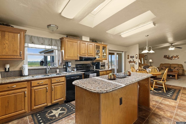 kitchen featuring black appliances, sink, ceiling fan, a kitchen island, and extractor fan