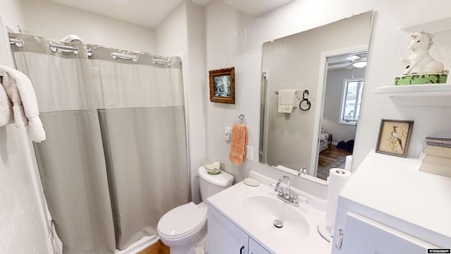 bathroom with ceiling fan, wood-type flooring, vanity, and toilet