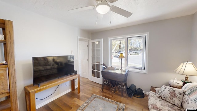 living room with light hardwood / wood-style floors and ceiling fan