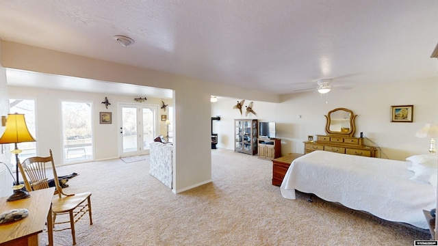 bedroom featuring access to outside, french doors, a textured ceiling, light carpet, and ceiling fan