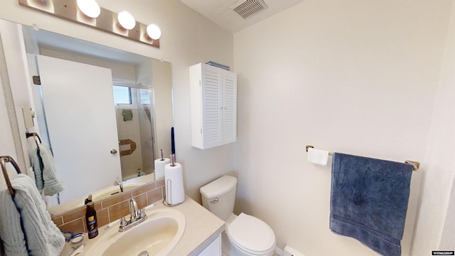 bathroom with toilet, vanity, and a shower with door