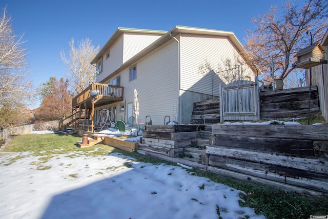 snow covered house featuring a deck