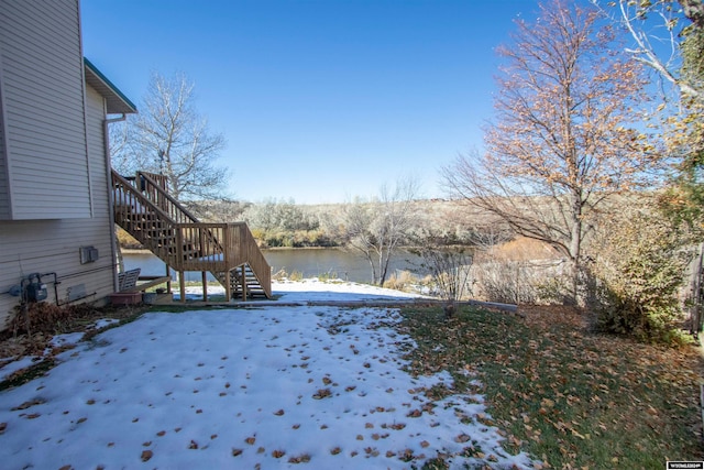 snowy yard with a water view