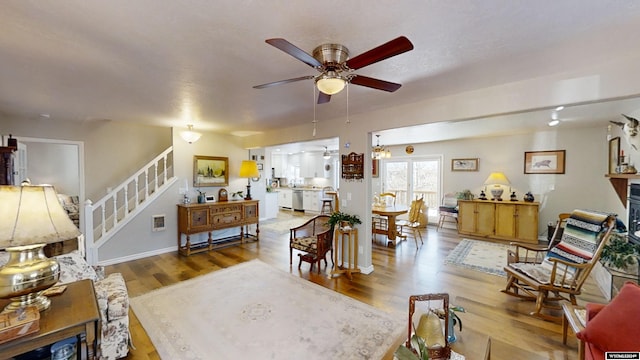 living room featuring hardwood / wood-style floors and ceiling fan with notable chandelier