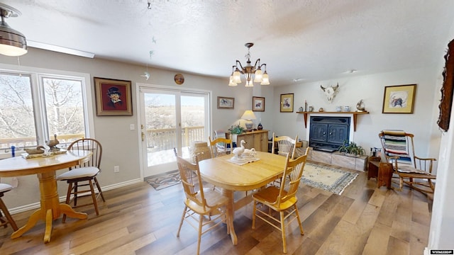 dining room with a textured ceiling, light hardwood / wood-style flooring, and a chandelier