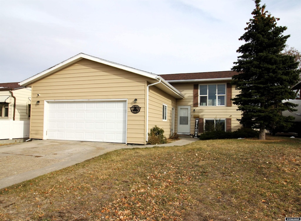 view of front of home with a garage and a front lawn