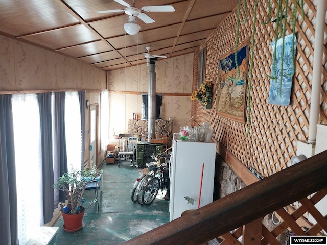 misc room with a wood stove and ceiling fan