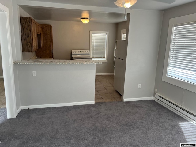 kitchen featuring dark colored carpet, range, fridge, and kitchen peninsula