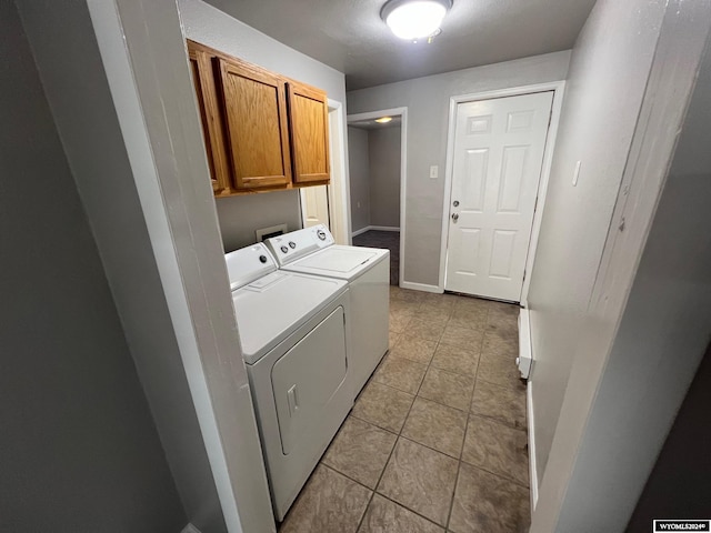 laundry room with cabinets, washing machine and dryer, and light tile patterned flooring