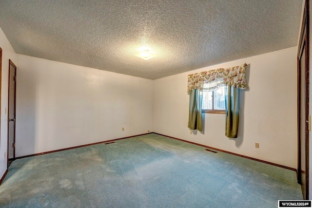 carpeted spare room with a textured ceiling