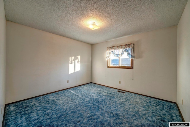 empty room featuring a textured ceiling and carpet floors