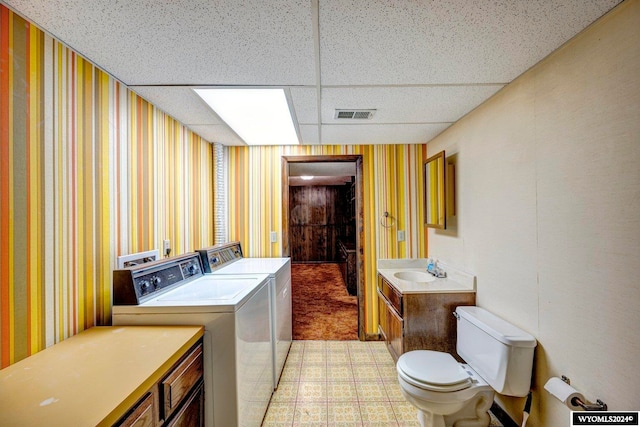 washroom featuring washer and clothes dryer, sink, and light colored carpet