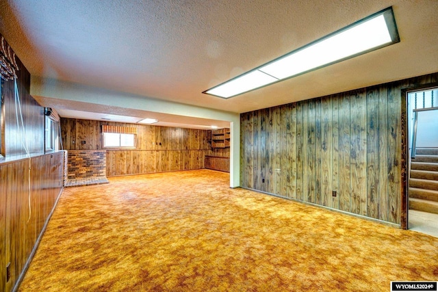 basement with wooden walls, a textured ceiling, and carpet