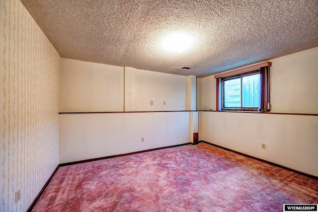 carpeted spare room featuring a textured ceiling