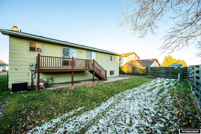 back of property featuring a wooden deck, cooling unit, a lawn, and a patio