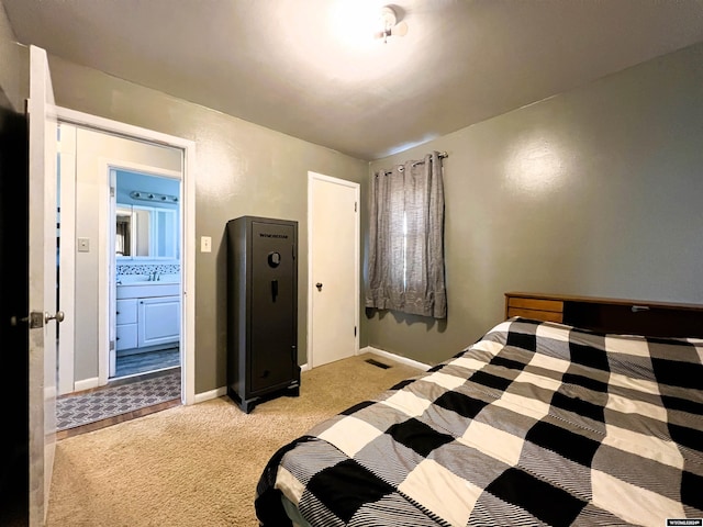 bedroom featuring ensuite bathroom and light carpet