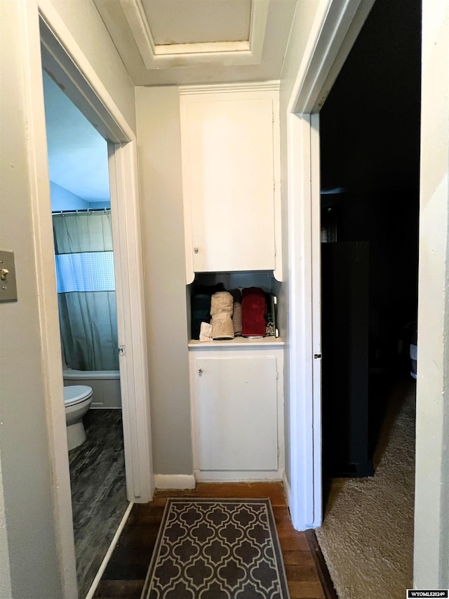 bathroom featuring hardwood / wood-style floors, toilet, and shower / tub combo with curtain