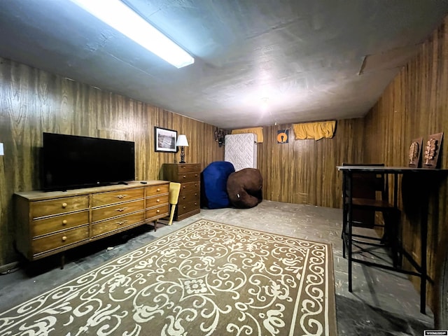 bedroom with wooden walls and concrete floors