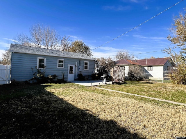 rear view of property featuring a yard and a patio area