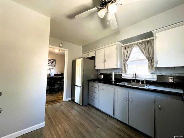 kitchen with white cabinets, stainless steel refrigerator, sink, and dark wood-type flooring