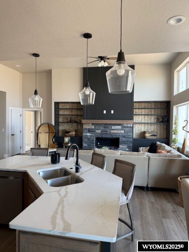 3698 Red Wolf Dr, Casper, WY 82604 - kitchen featuring a sink, dishwasher, a textured ceiling, light wood-style floors, and open floor plan