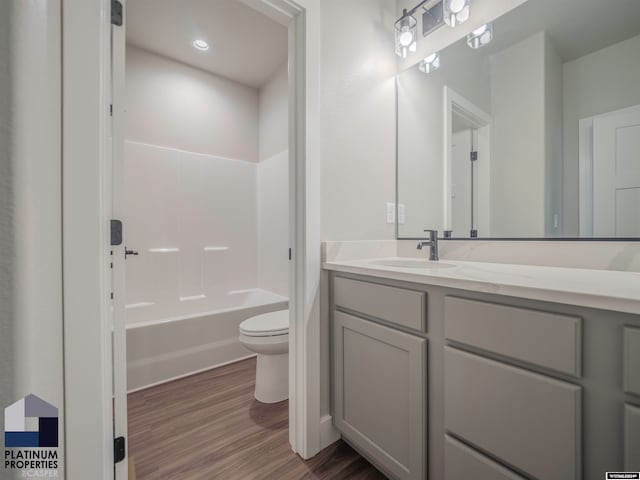 bathroom featuring bathing tub / shower combination, toilet, wood finished floors, vanity, and recessed lighting