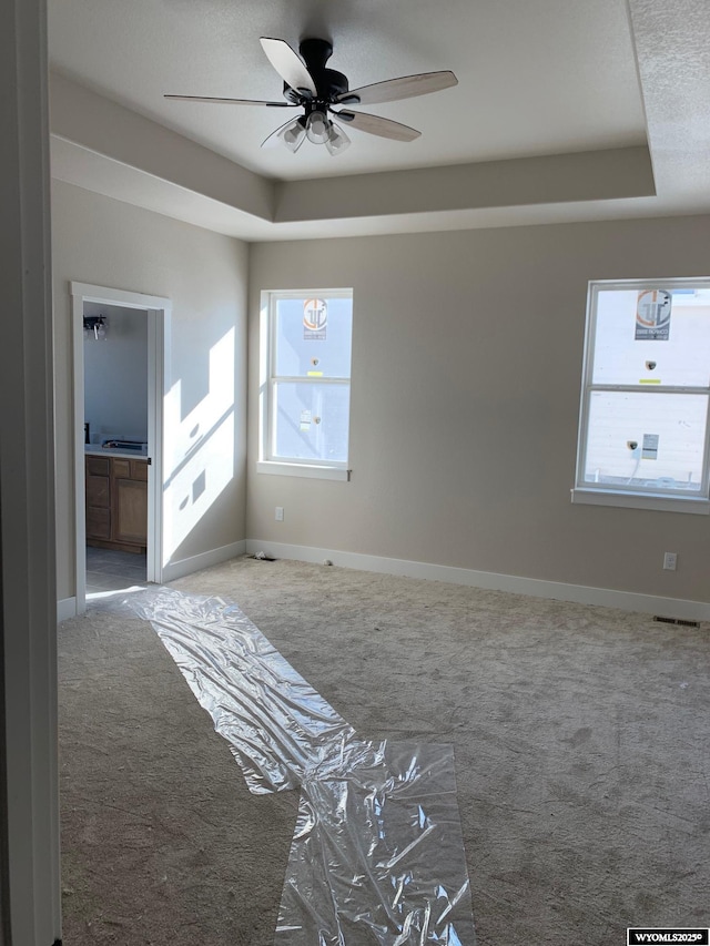3698 Red Wolf Dr, Casper, WY 82604 - carpeted spare room with a tray ceiling, ceiling fan, and baseboards