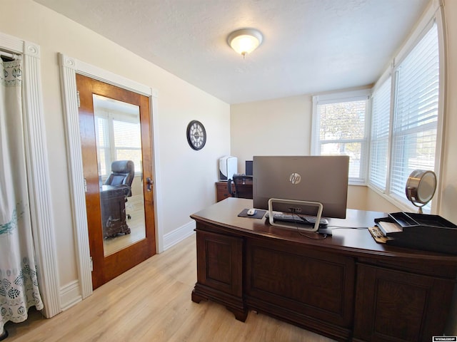 office featuring light hardwood / wood-style floors, a textured ceiling, and a wealth of natural light