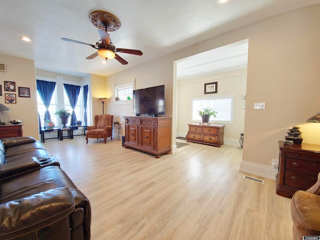 living room with light wood-type flooring, plenty of natural light, and ceiling fan