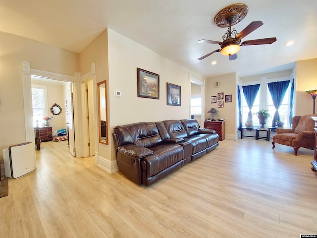 living room with ceiling fan and light hardwood / wood-style flooring