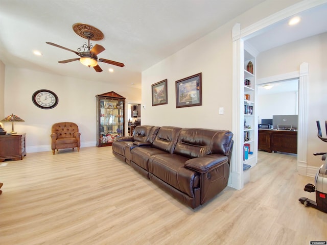 living room with ceiling fan, light hardwood / wood-style flooring, and built in shelves