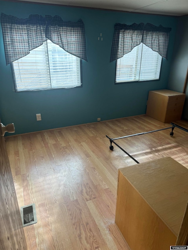 empty room featuring a wealth of natural light and hardwood / wood-style floors