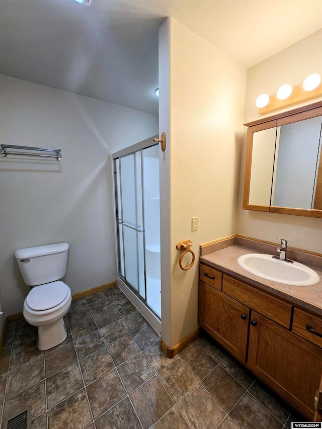 bathroom featuring vanity, toilet, and an enclosed shower