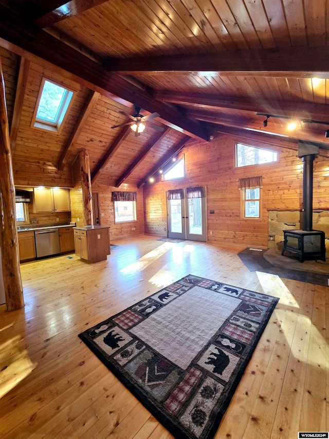 interior space with light hardwood / wood-style floors, a wood stove, and wood ceiling