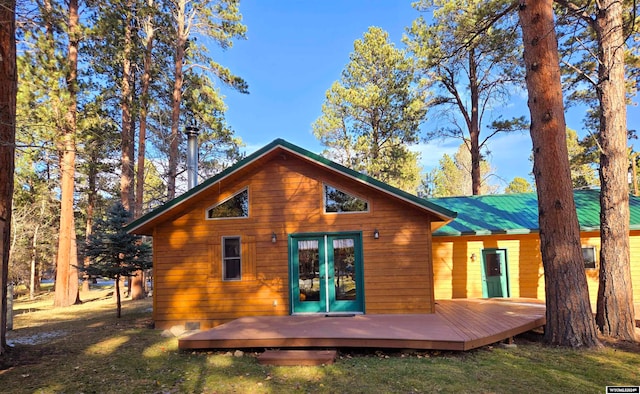 rear view of property with a yard, french doors, and a deck