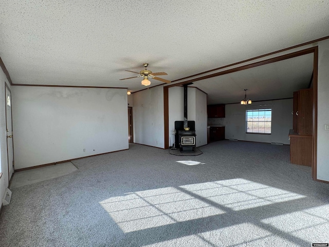 unfurnished living room with carpet, a textured ceiling, ceiling fan, a wood stove, and lofted ceiling