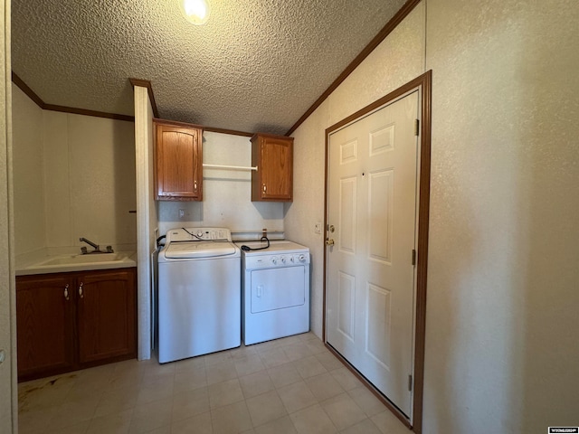 laundry area featuring cabinets, a textured ceiling, crown molding, sink, and separate washer and dryer