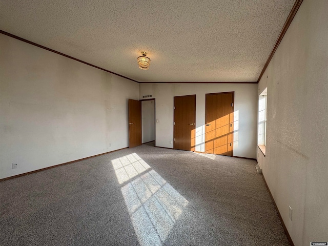 unfurnished bedroom with a textured ceiling, carpet floors, and ornamental molding