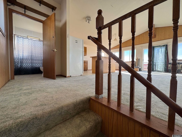 staircase featuring beam ceiling, carpet floors, and high vaulted ceiling