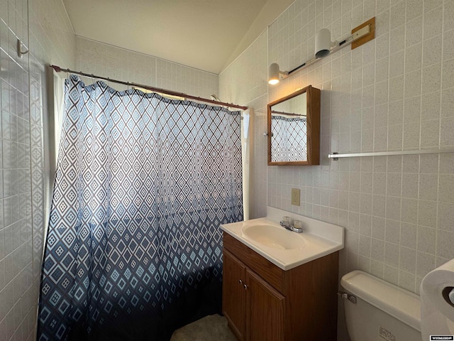 bathroom with vanity, curtained shower, toilet, and tile walls