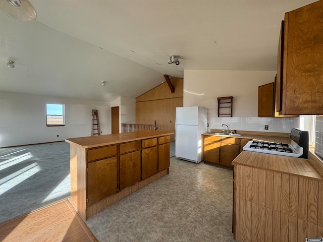 kitchen featuring lofted ceiling, plenty of natural light, white appliances, and sink