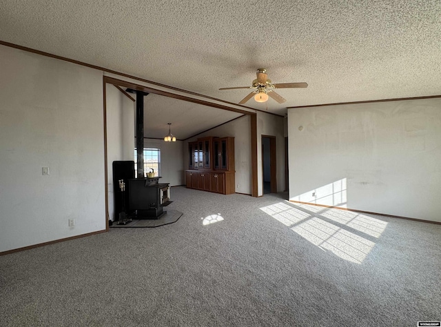 unfurnished living room featuring a textured ceiling, carpet floors, a wood stove, and ceiling fan