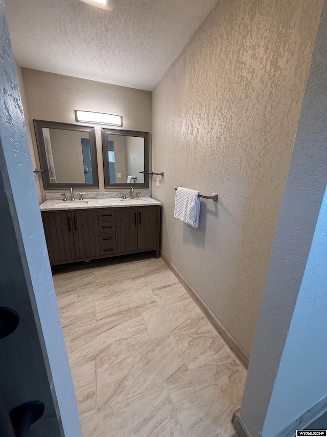 bathroom featuring a textured ceiling and vanity