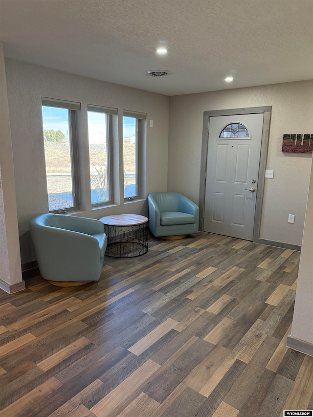 entryway with dark hardwood / wood-style flooring and a textured ceiling