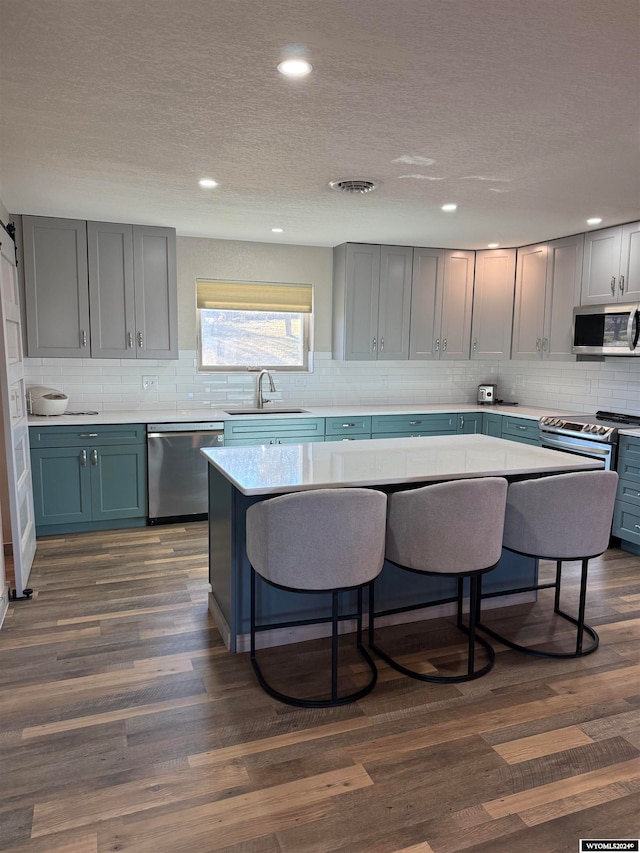 kitchen featuring appliances with stainless steel finishes, dark hardwood / wood-style flooring, and sink