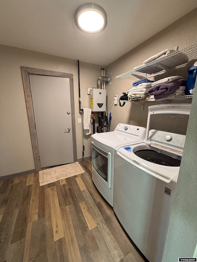 laundry room with dark hardwood / wood-style flooring, independent washer and dryer, and water heater