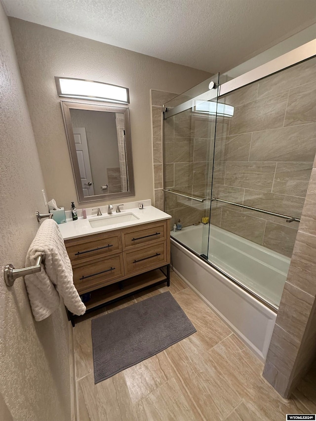 bathroom with vanity, enclosed tub / shower combo, a textured ceiling, and wood-type flooring